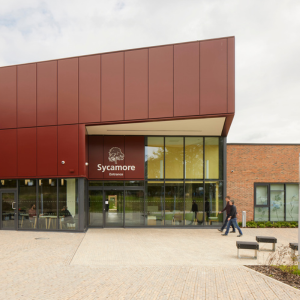 picture of a modern single story building. the entrance says sycamore with a design of a tree